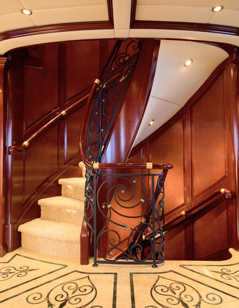a staircase with a large wooden staircase aboard AMARULA SUN Yacht for Sale