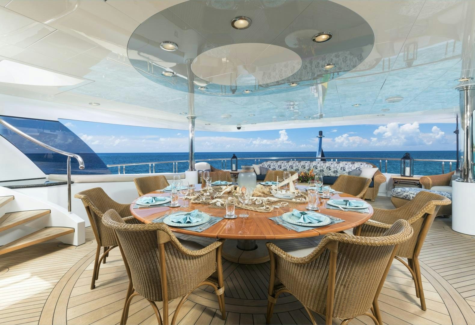 a table set for a meal on a deck overlooking the ocean aboard AMARULA SUN Yacht for Sale