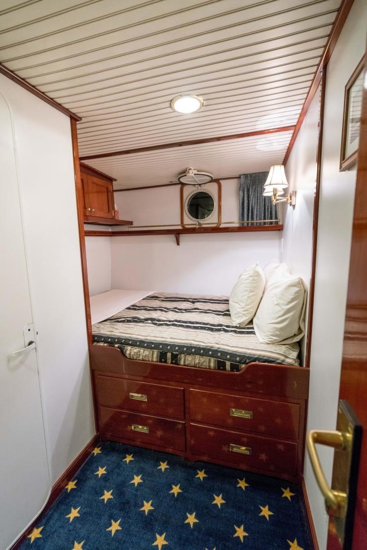a bedroom with a bed and a mirror aboard ARABELLA II Yacht for Sale