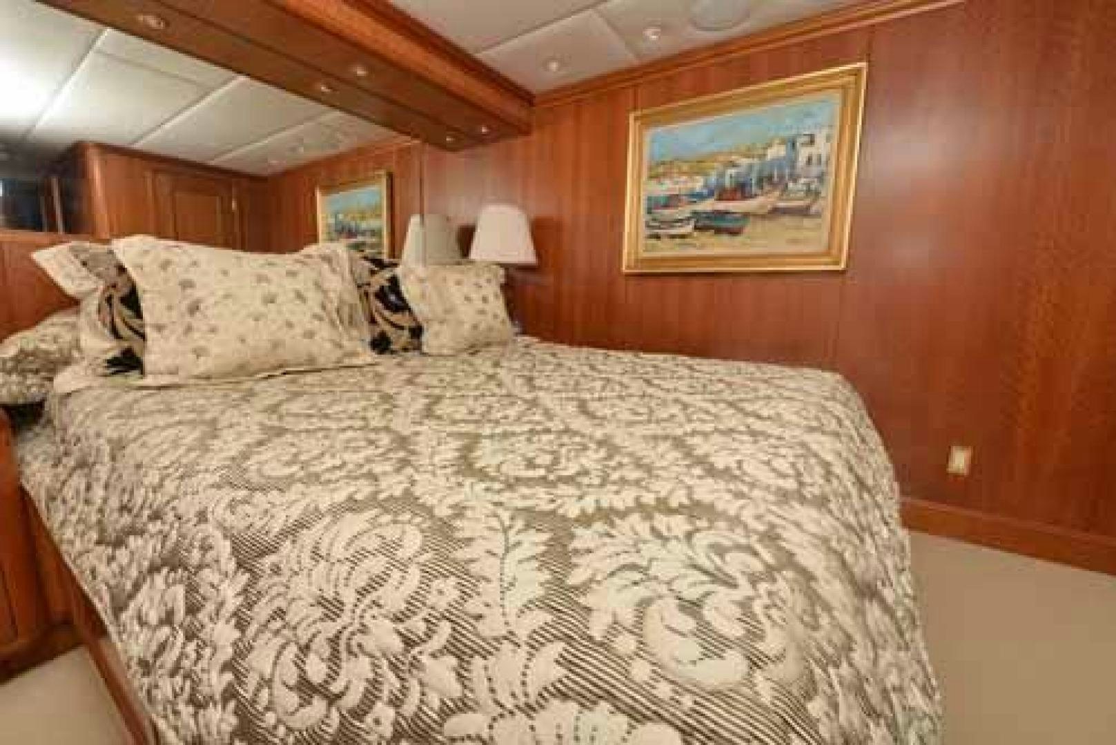 a bed with a white comforter aboard UTOPIA III Yacht for Sale