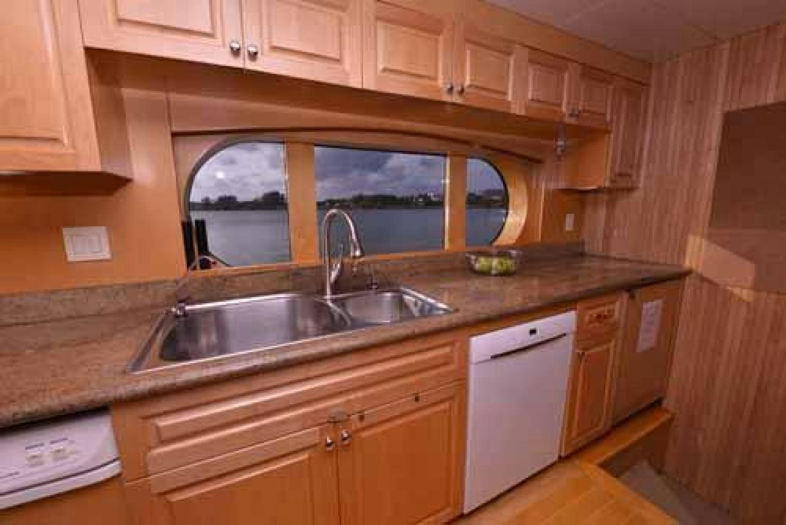 a kitchen with wooden cabinets aboard UTOPIA III Yacht for Sale