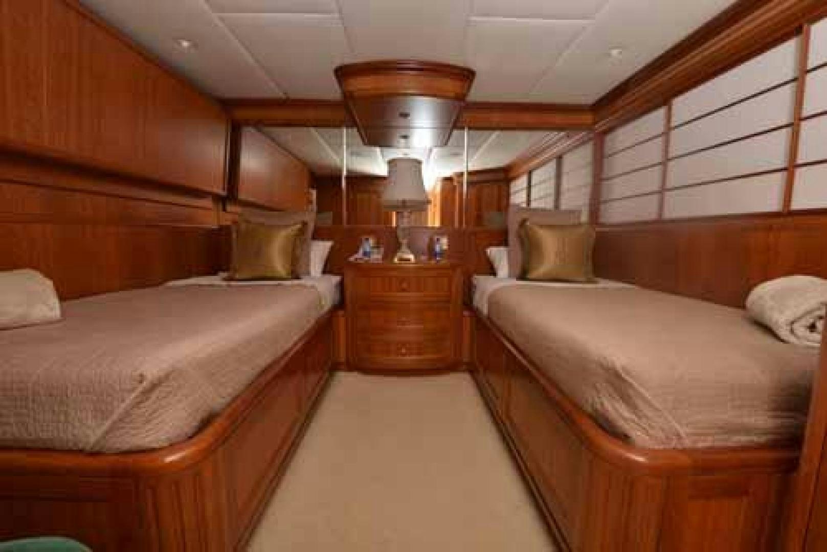 a room with beds and a lamp aboard UTOPIA III Yacht for Sale
