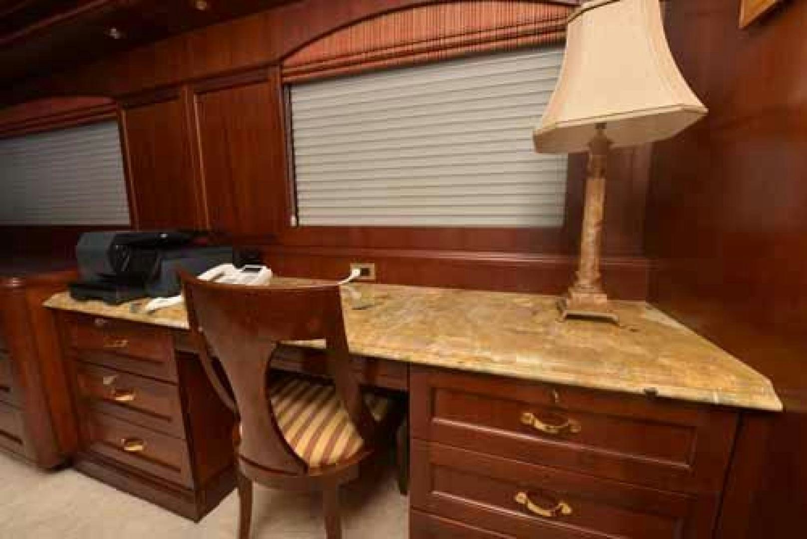 a desk with a lamp and a chair in a room aboard UTOPIA III Yacht for Sale
