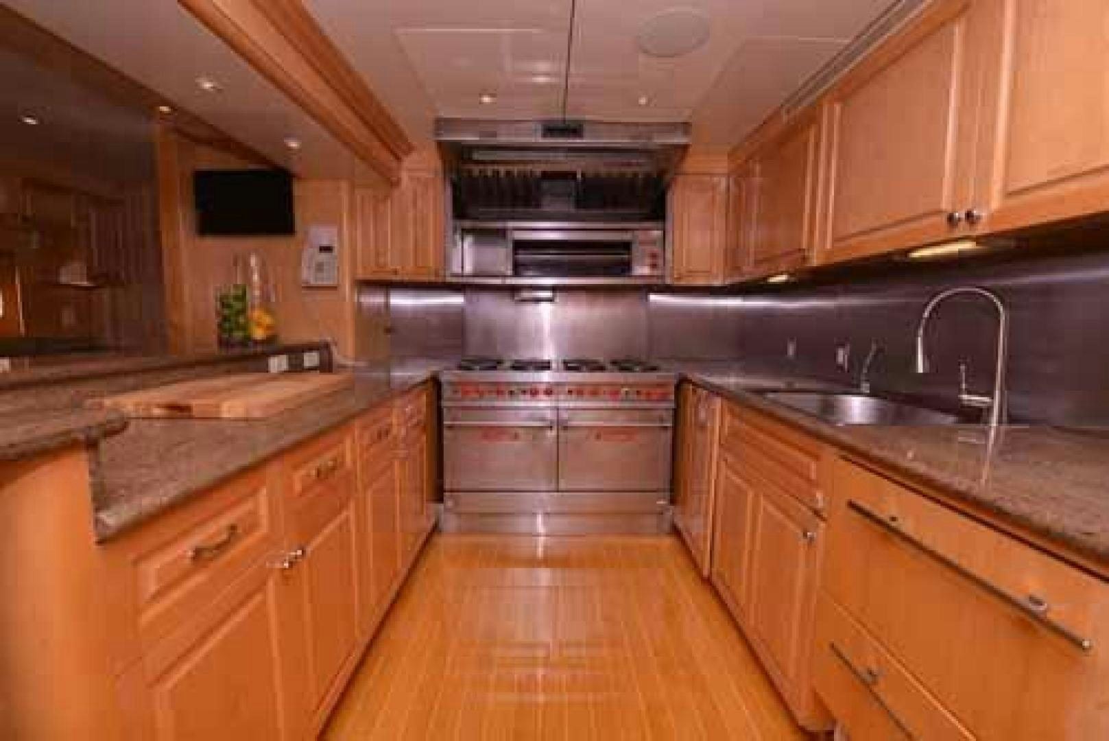 a kitchen with wooden cabinets aboard UTOPIA III Yacht for Sale