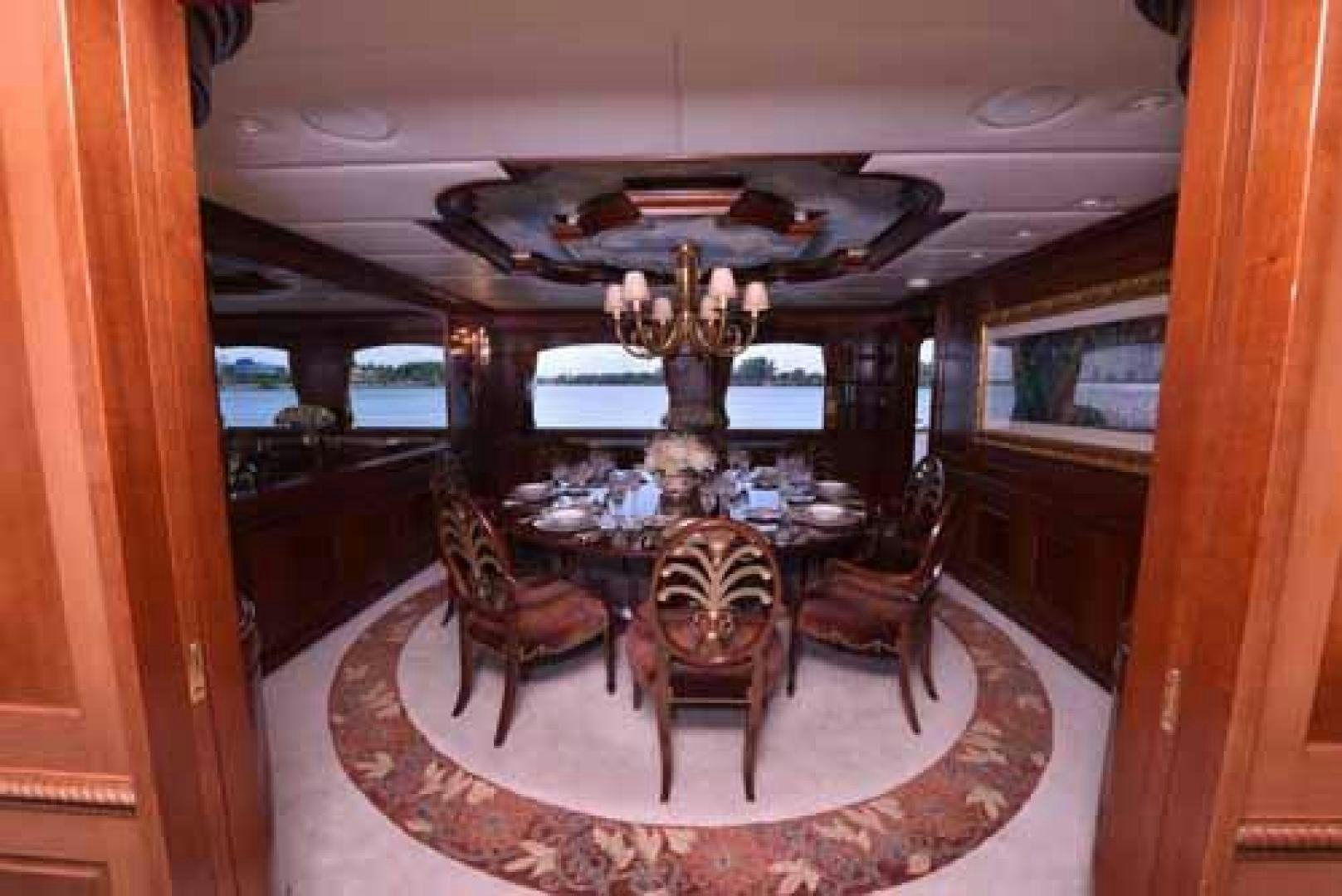 a dining room with a chandelier aboard UTOPIA III Yacht for Sale