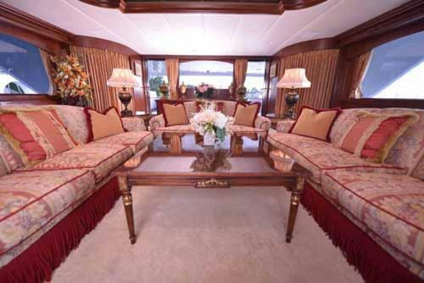 a living room with a table and couches aboard UTOPIA III Yacht for Sale