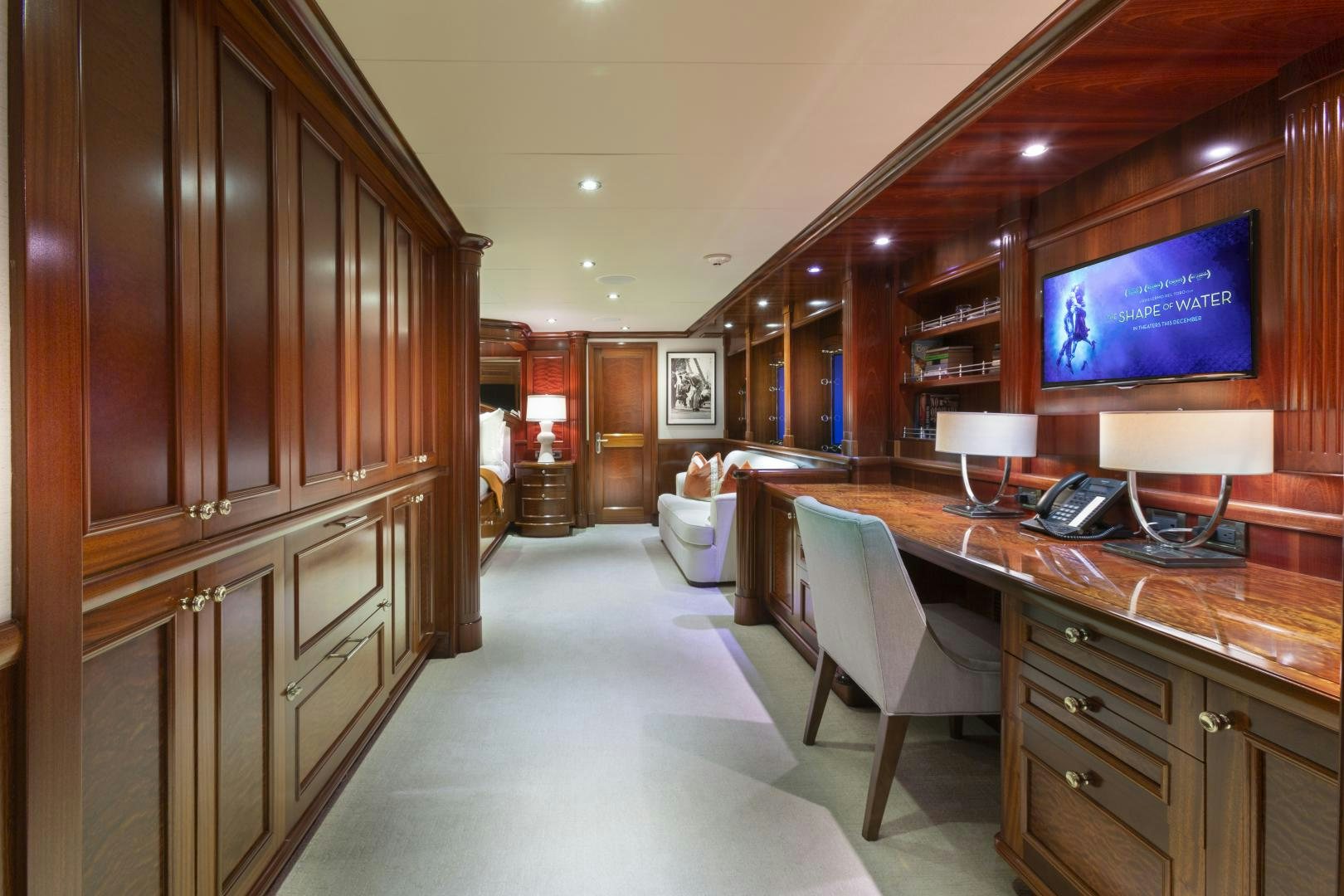 a room with a desk and a tv on the wall aboard FAR FROM IT Yacht for Sale