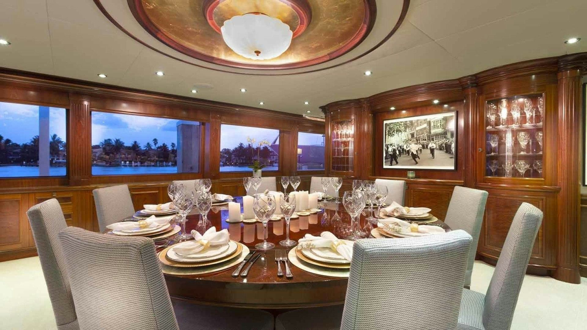 a dining room with a table set for a dinner aboard FAR FROM IT Yacht for Sale