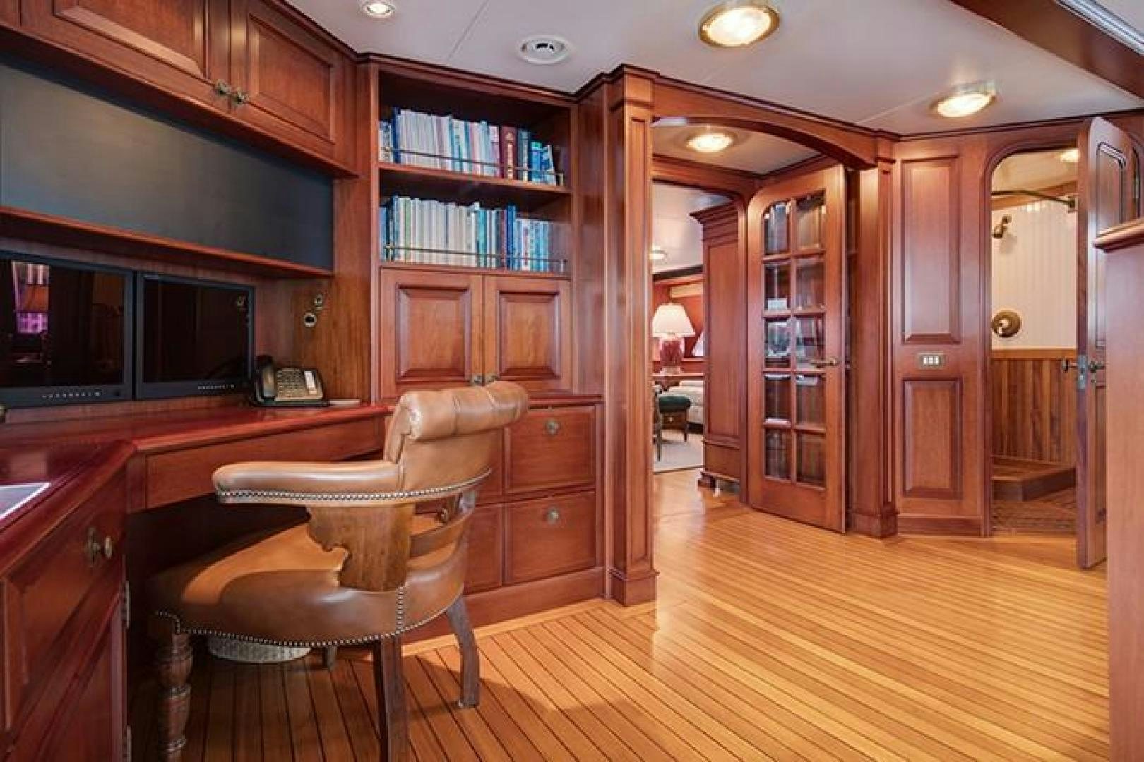 a room with a wood floor and a wood cabinet with a chair and a wood floor aboard MARLINDA Yacht for Sale