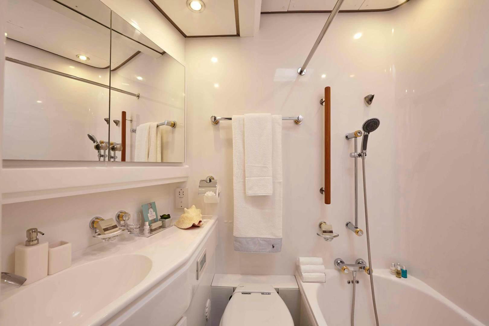 a bathroom with a shower sink and a mirror aboard LATITUDE Yacht for Sale