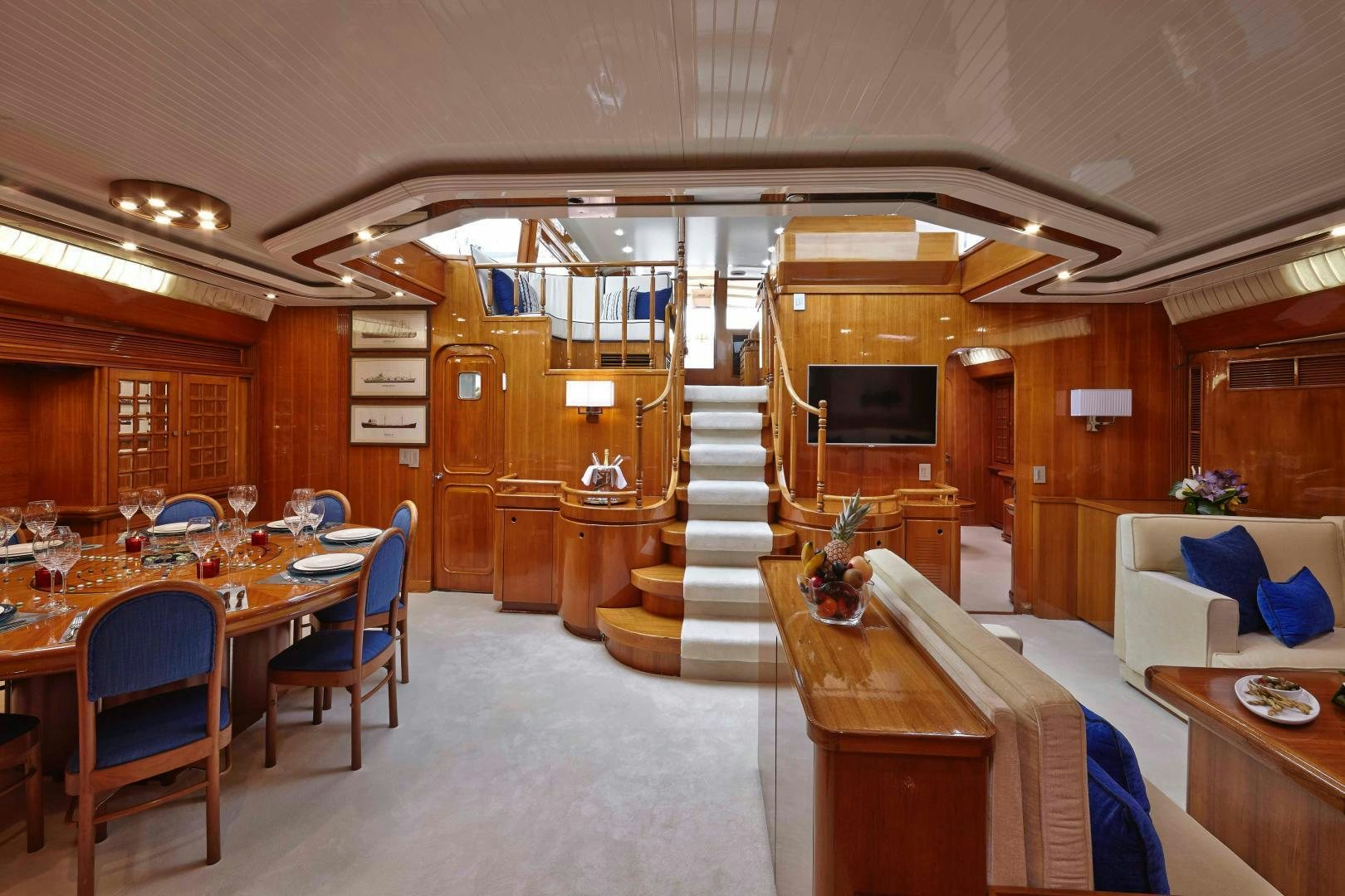 a large room with a staircase and a table aboard LATITUDE Yacht for Sale