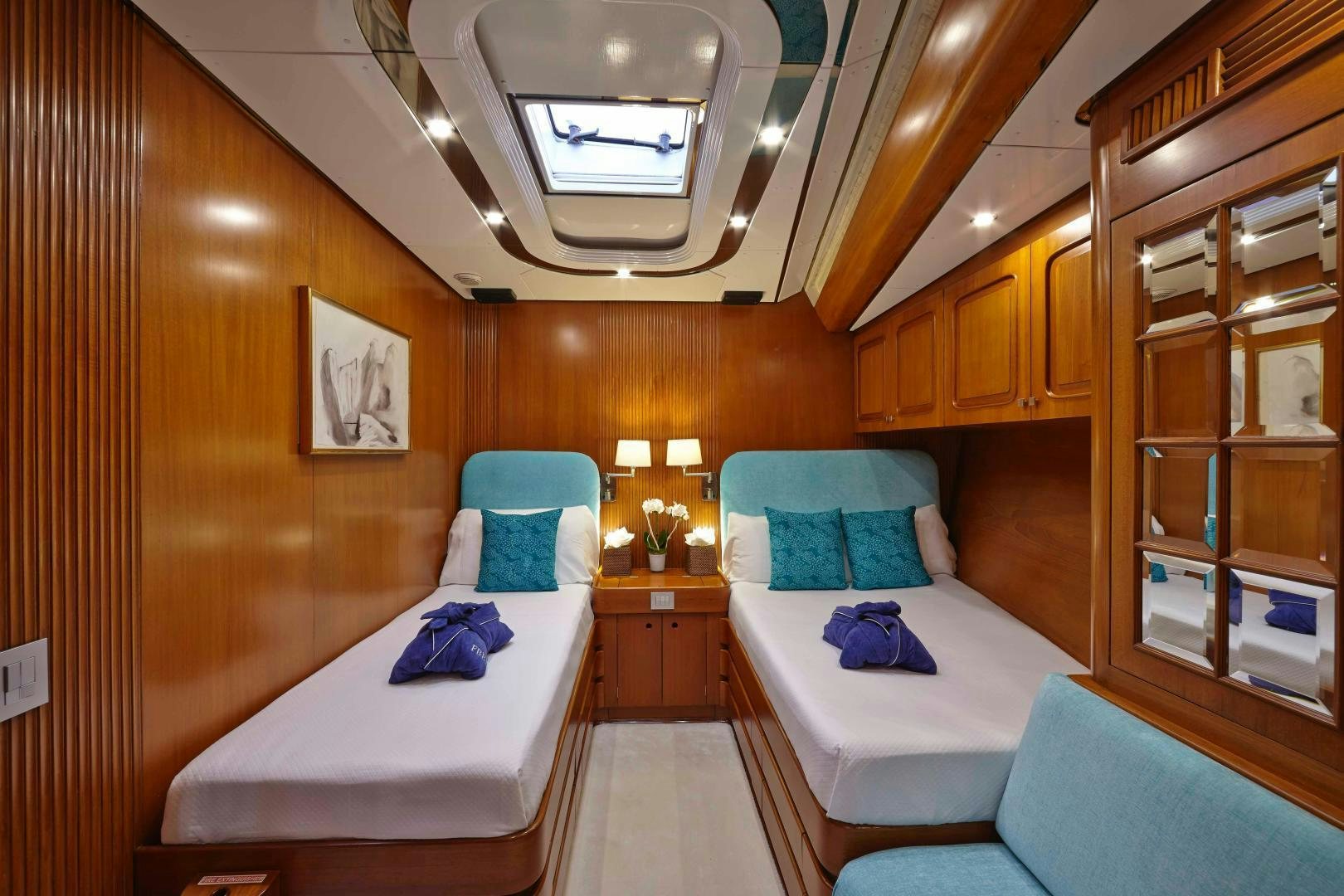 a room with beds and a mirror aboard LATITUDE Yacht for Sale