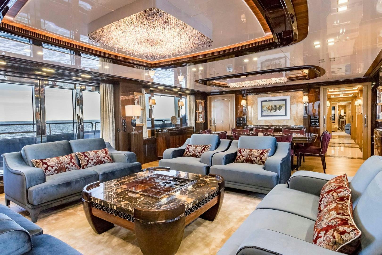 a living room with a large chandelier aboard VIATORIS Yacht for Sale