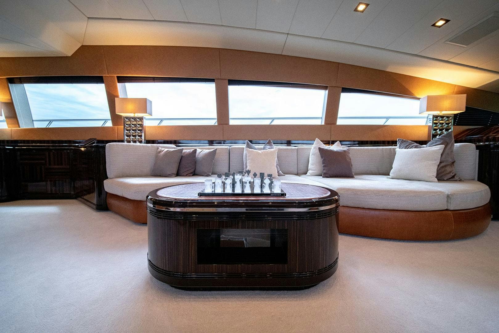 a large living room with a large couch and a fireplace aboard HARMONIC WAVES Yacht for Sale