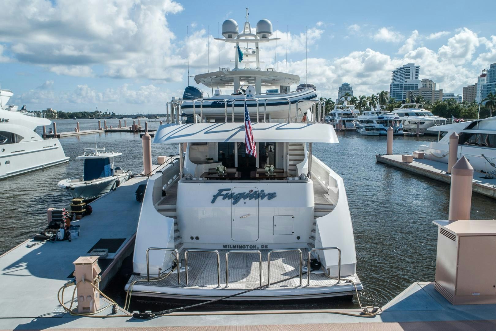 a large white boat sits in a harbor aboard FUGITIVE *NAME RESERVED* Yacht for Sale