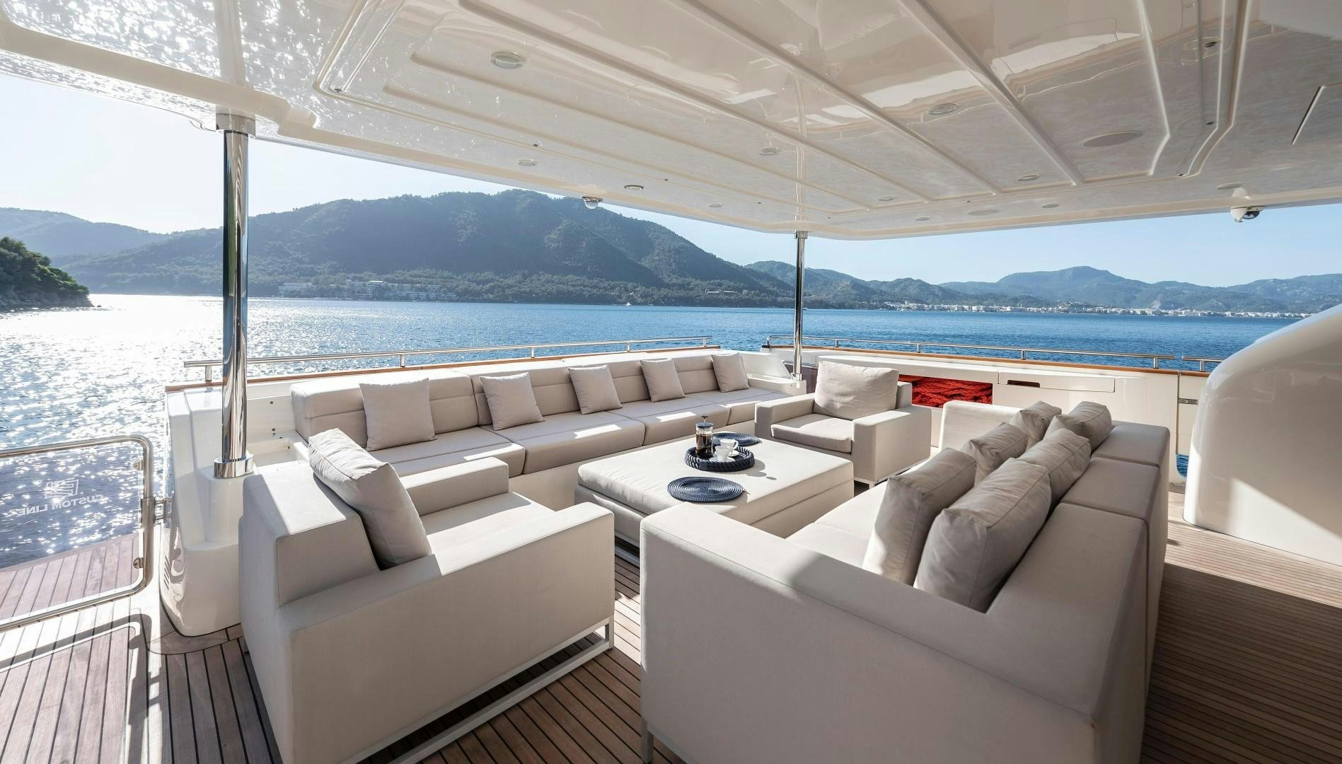 a living room with a large body of water in the background aboard ARGENTO Yacht for Sale