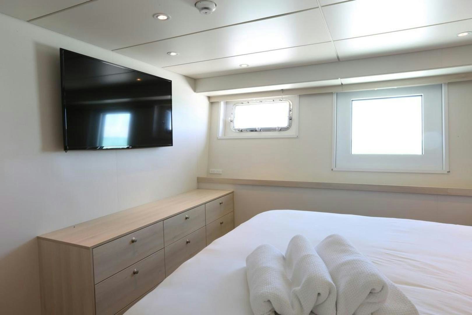 a room with a bed and a tv aboard KAHU Yacht for Sale
