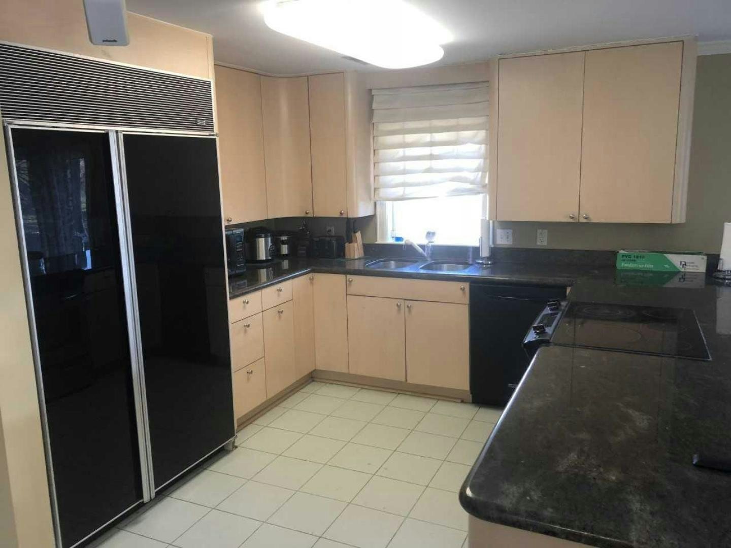 a kitchen with black appliances aboard LAKEHOUSE Yacht for Sale