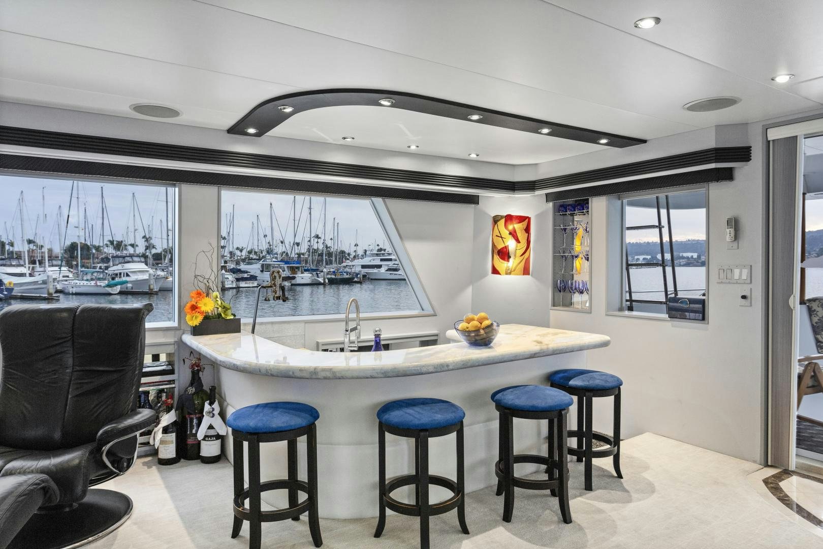 a large white table with stools and stools in a room with a large window and a aboard ISABELLA Yacht for Sale