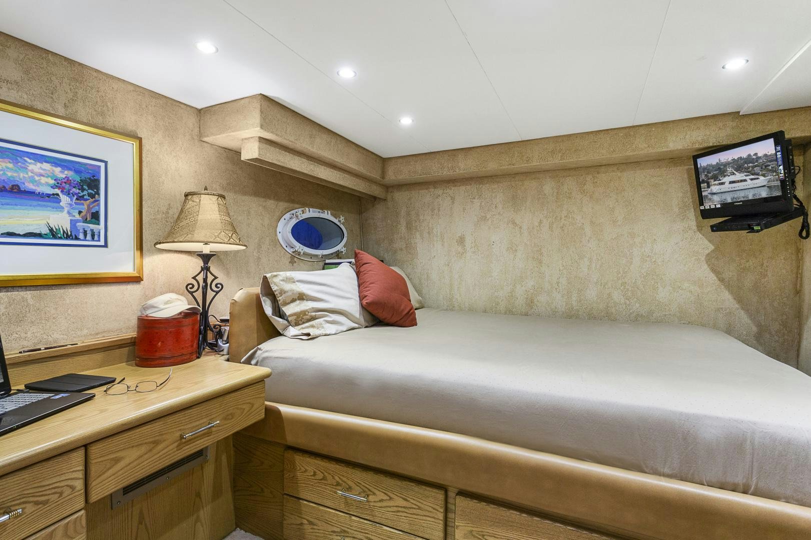 a bed with a desk and a television on the wall aboard ISABELLA Yacht for Sale