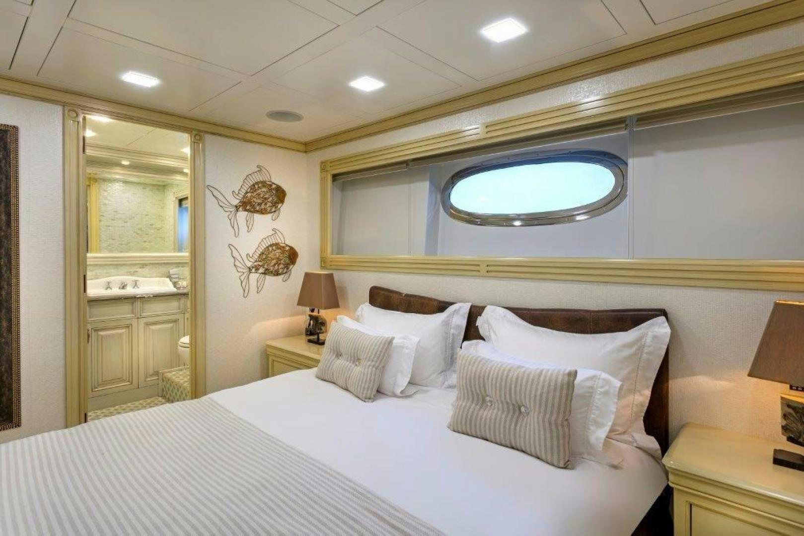 a bed with a white bed spread aboard M&M Yacht for Sale