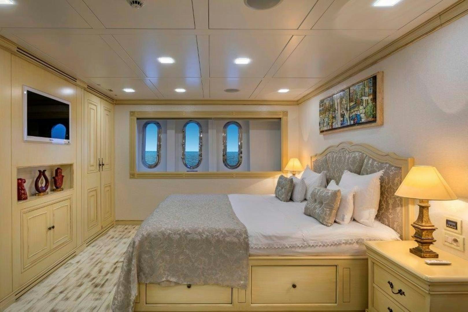 a bedroom with a bed and a lamp aboard M&M Yacht for Sale