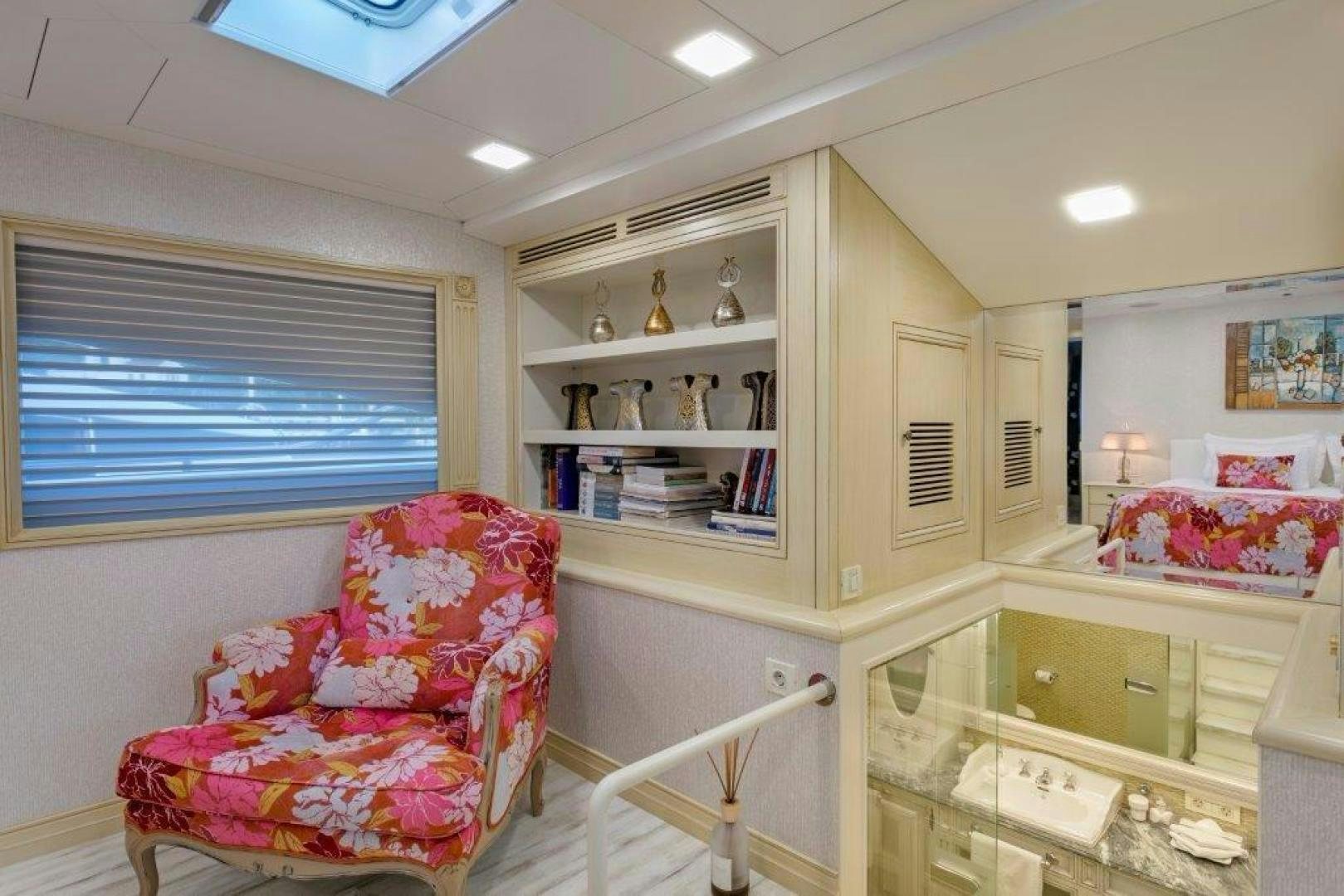 a room with a pink chair and shelves aboard M&M Yacht for Sale