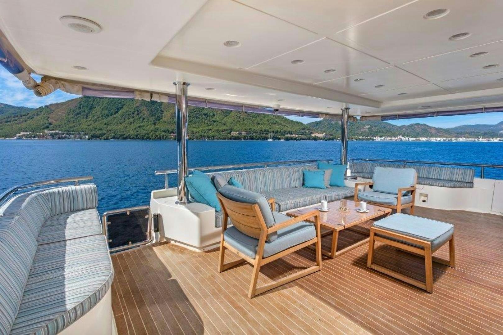 a deck with a table and chairs aboard M&M Yacht for Sale