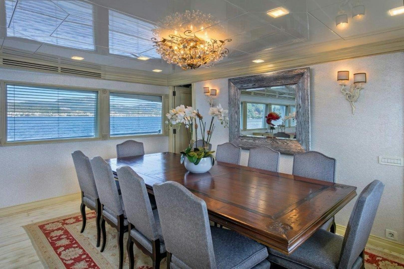 a large dining room with a large chandelier aboard M&M Yacht for Sale