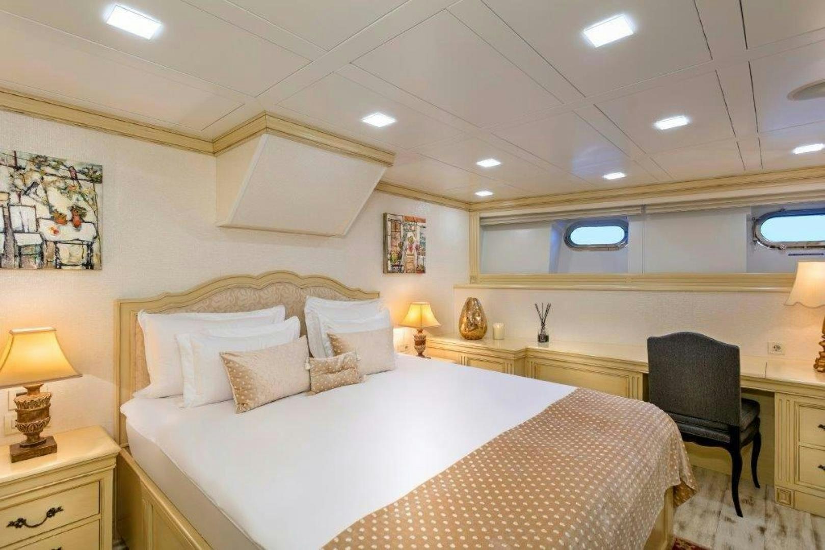 a bedroom with a bed and a desk aboard M&M Yacht for Sale