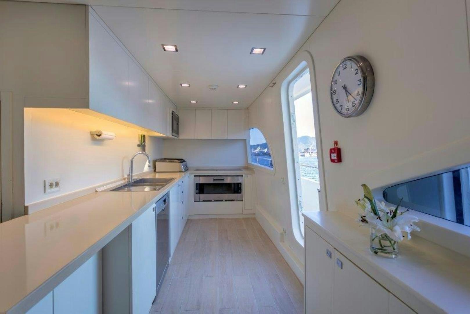 a kitchen with a large clock aboard M&M Yacht for Sale