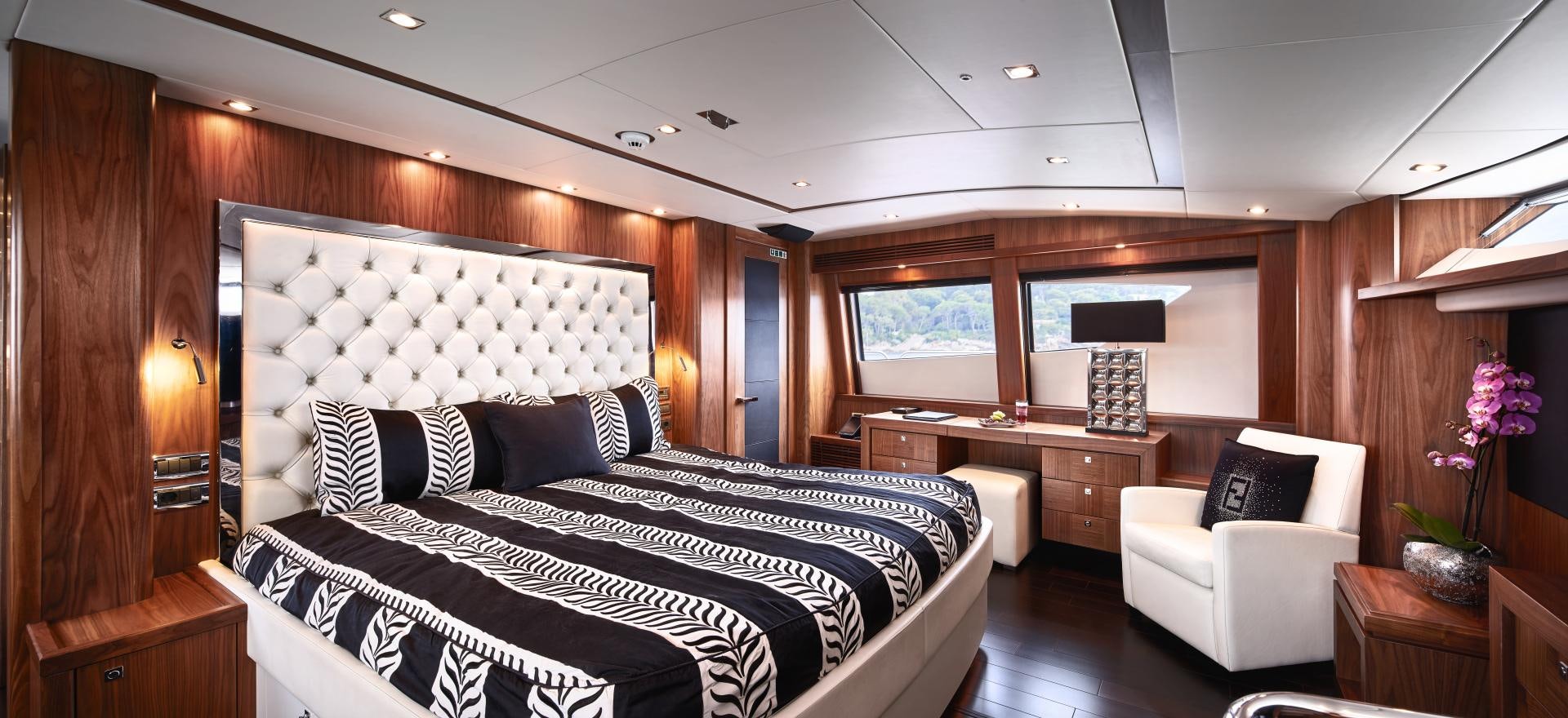 a bedroom with a bed and desk aboard BLACK AND WHITE Yacht for Sale