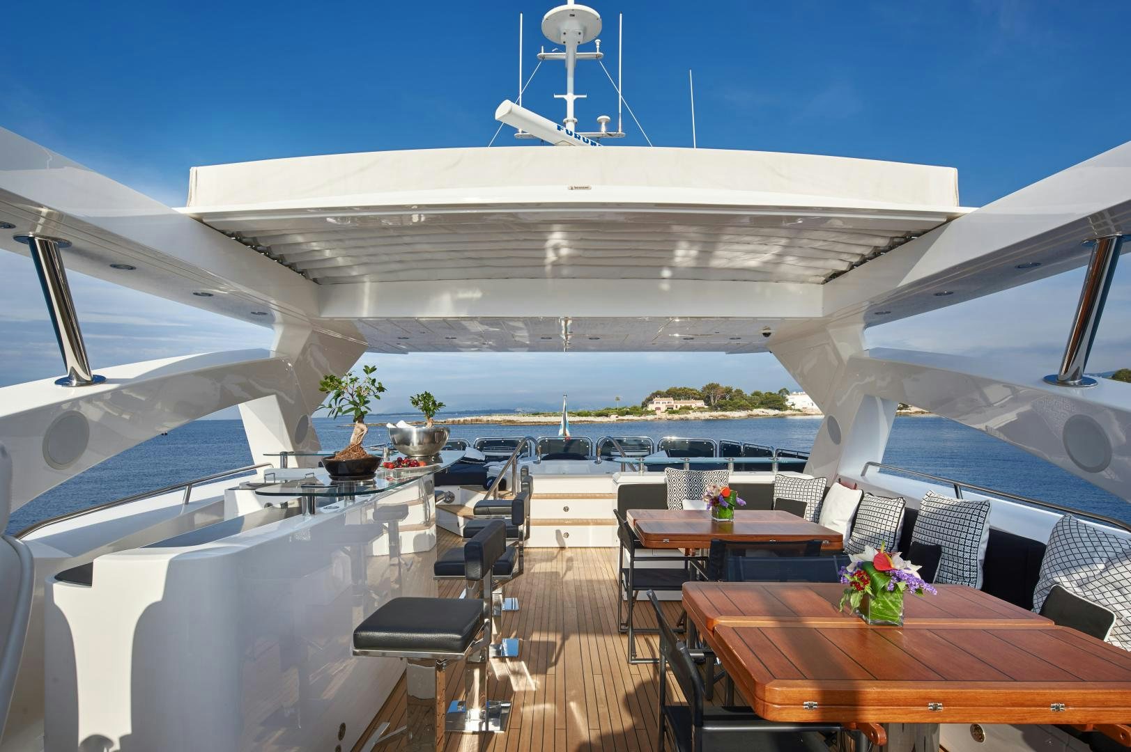 a large white building with a white roof and a table and chairs aboard BLACK AND WHITE Yacht for Sale
