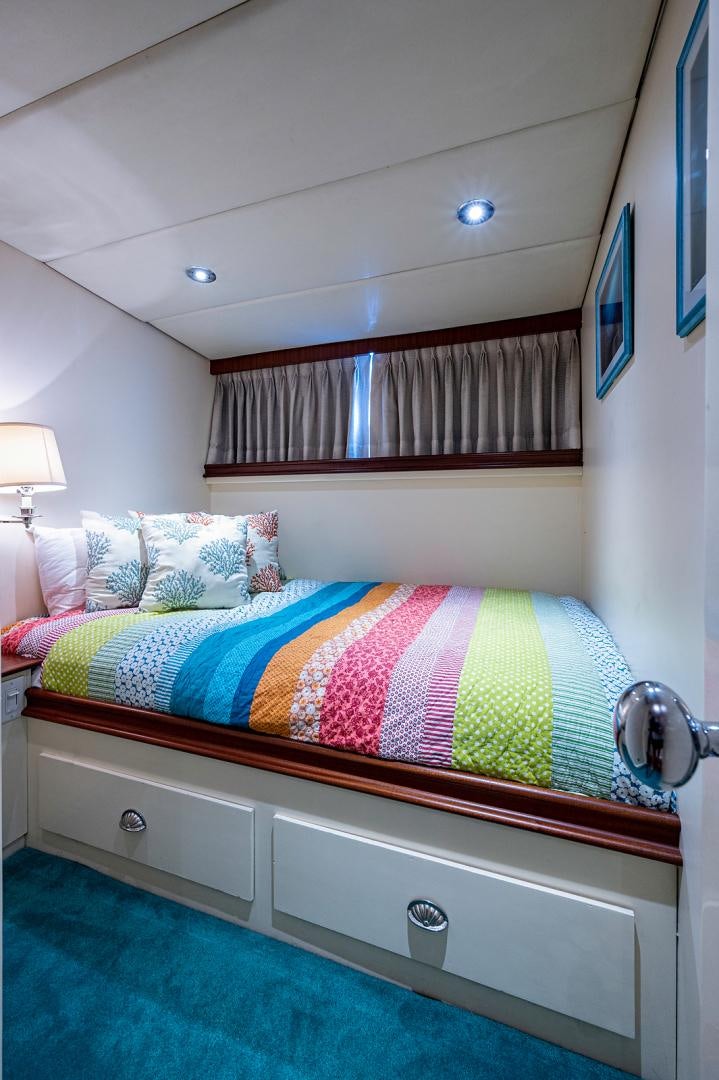 a bed with a colorful blanket aboard CHANTICLEER Yacht for Sale