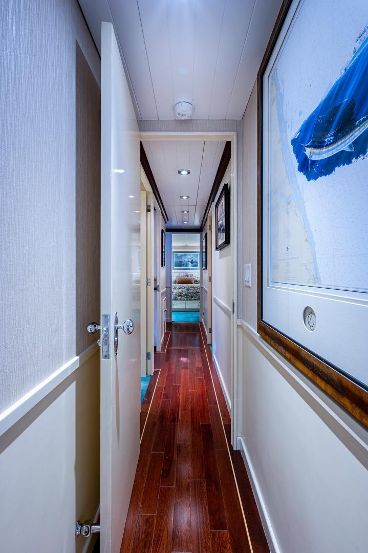 a hallway with a wood floor and blue walls aboard CHANTICLEER Yacht for Sale