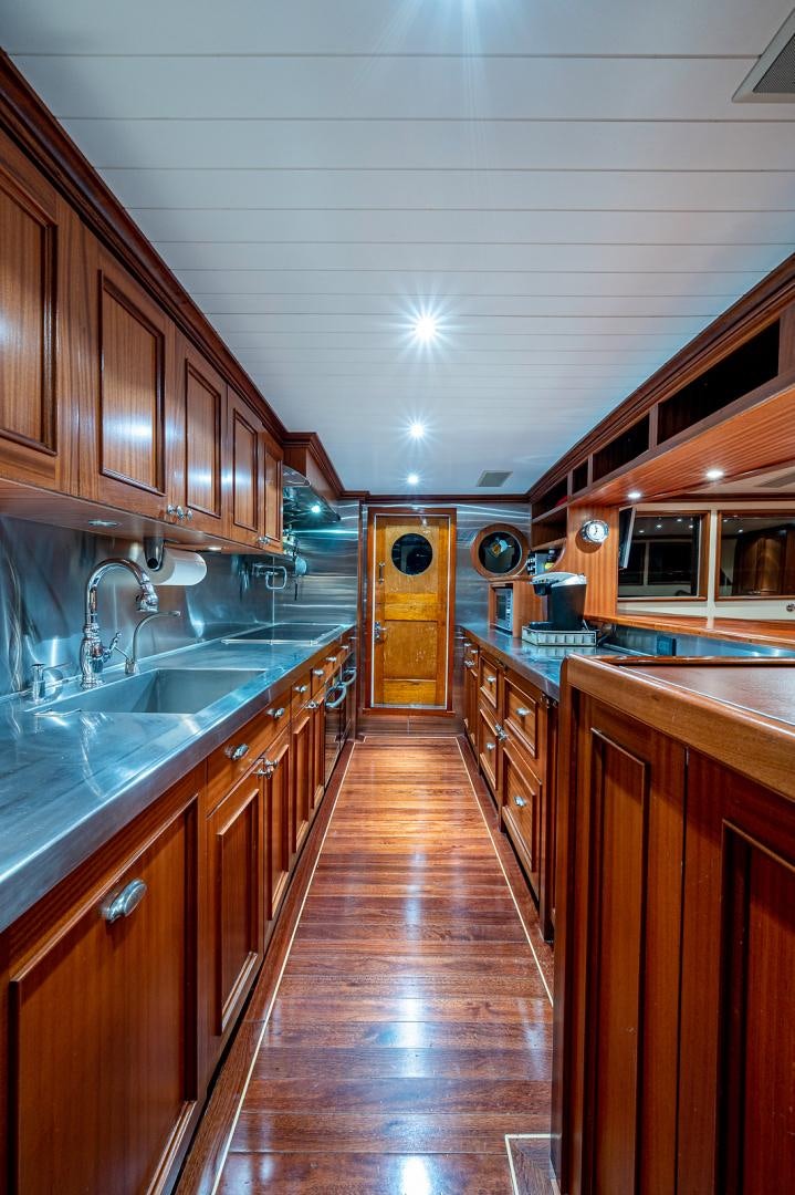 a kitchen with wooden cabinets aboard CHANTICLEER Yacht for Sale