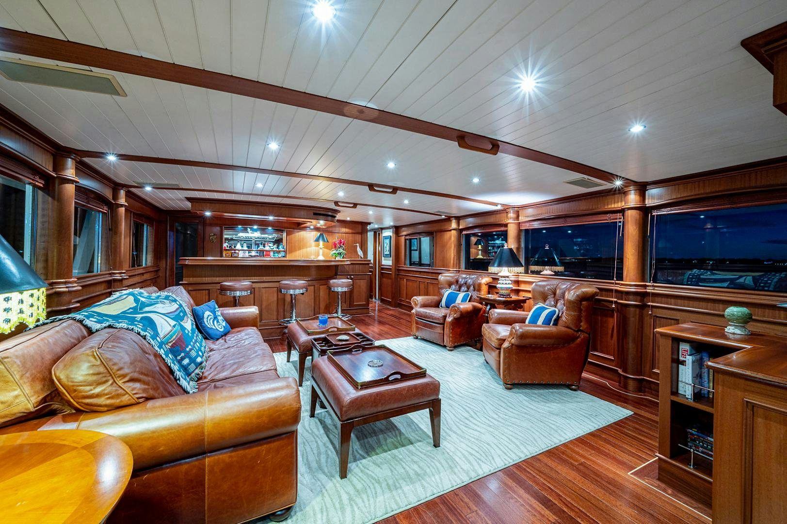 a living room with a large wood floor and a large window aboard CHANTICLEER Yacht for Sale