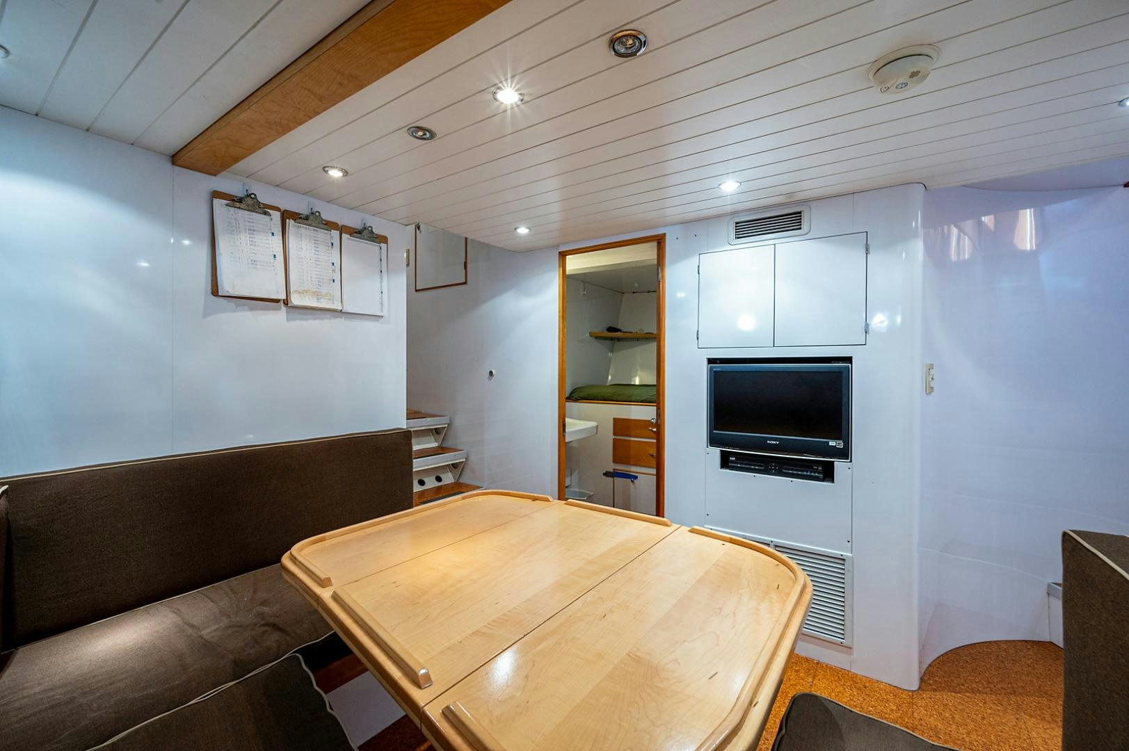 a living room with a table and tv aboard CHANTICLEER Yacht for Sale