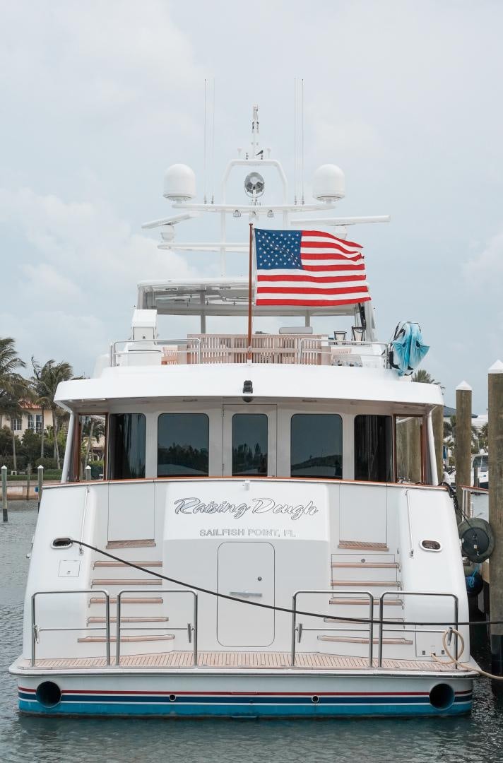 a boat with a flag on it aboard RAISING DOUGH Yacht for Sale