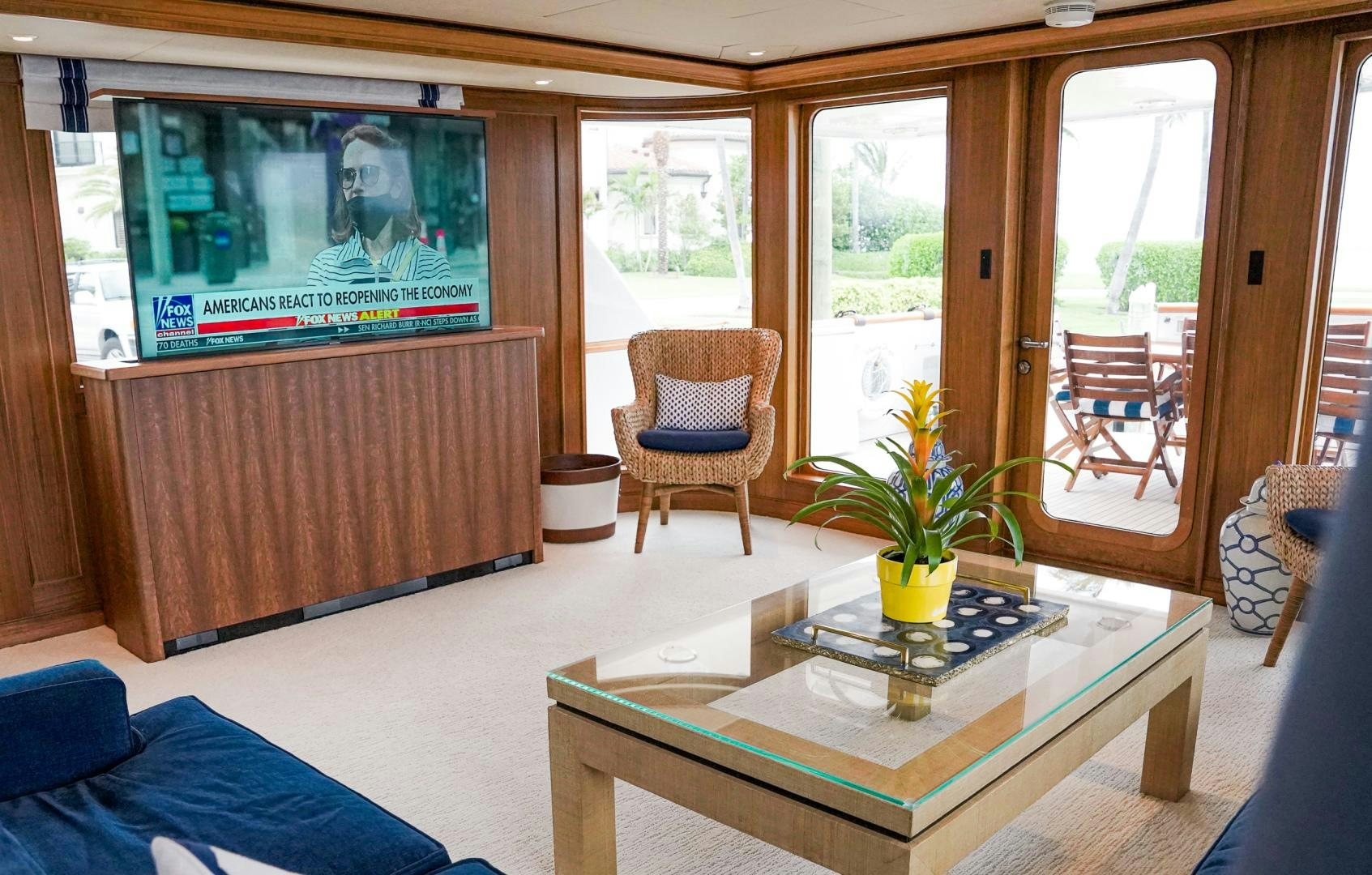 a living room with a tv and furniture aboard RAISING DOUGH Yacht for Sale