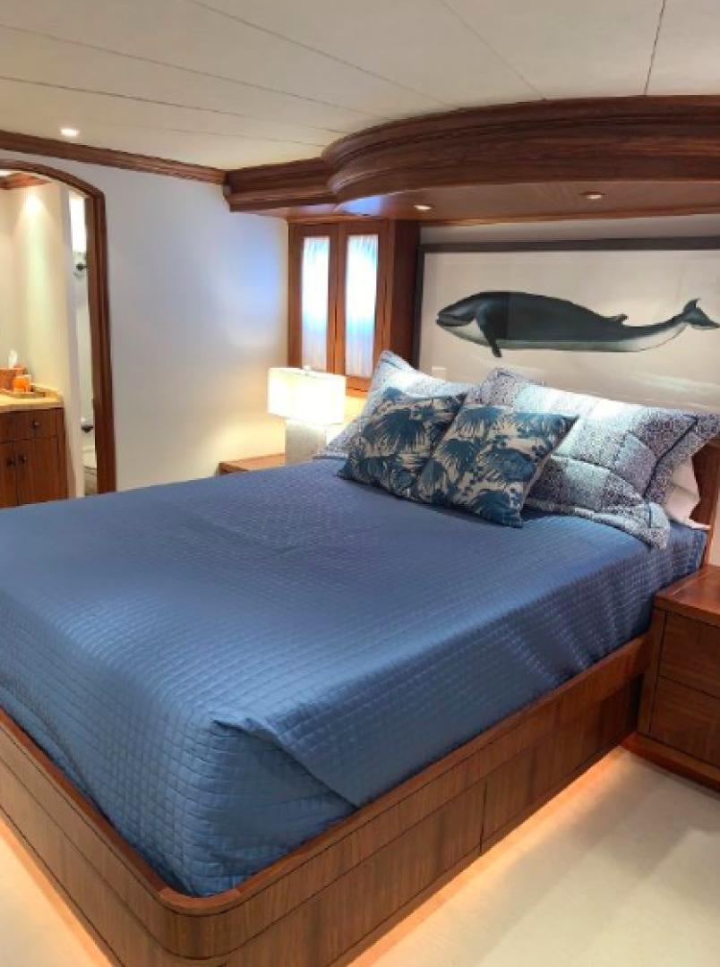 a bed with a blue comforter aboard RAISING DOUGH Yacht for Sale