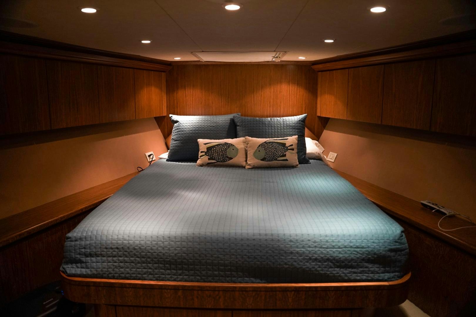 a bed with a blue and white comforter and pillows aboard RAISING DOUGH Yacht for Sale