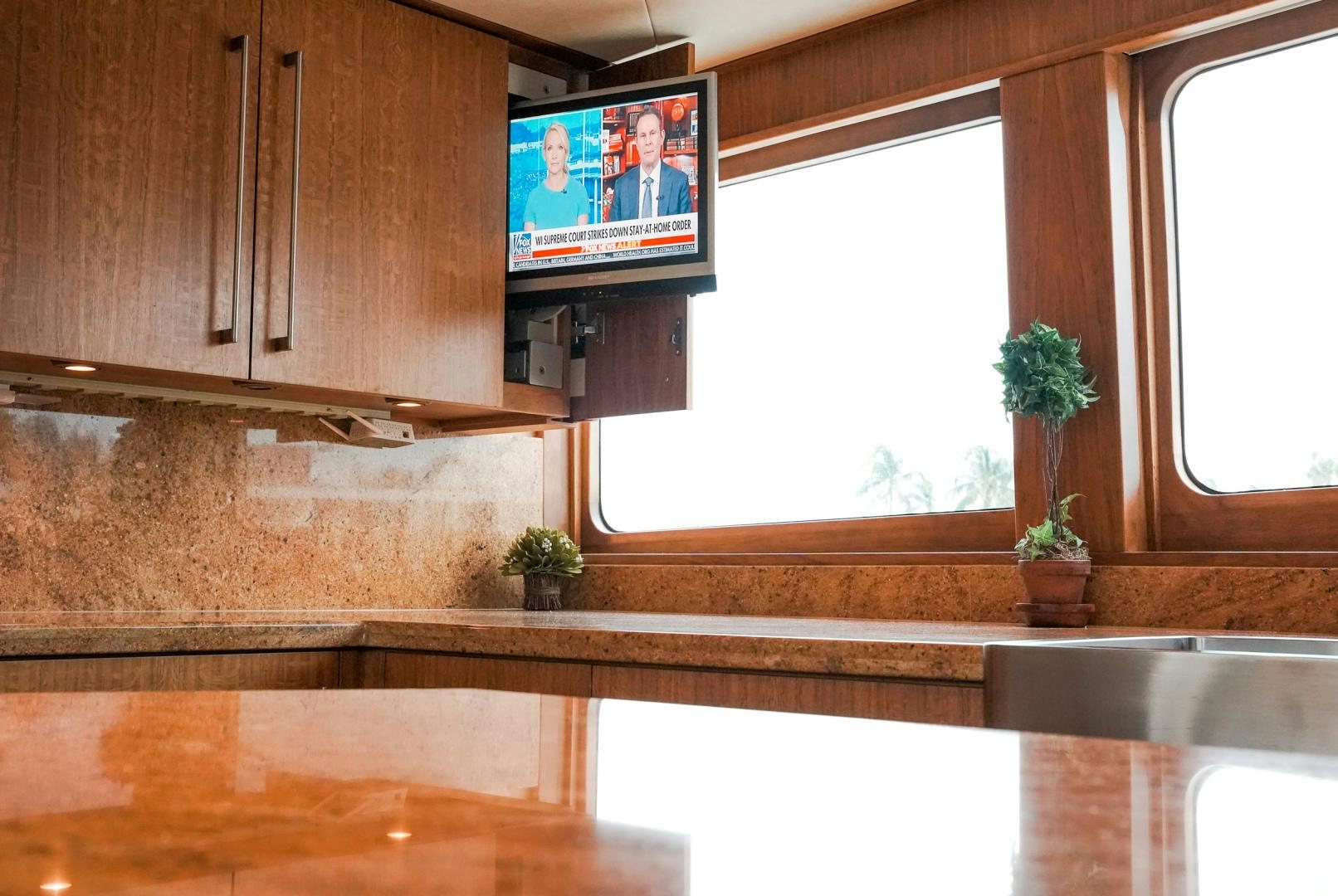 a kitchen with a television and a window aboard RAISING DOUGH Yacht for Sale