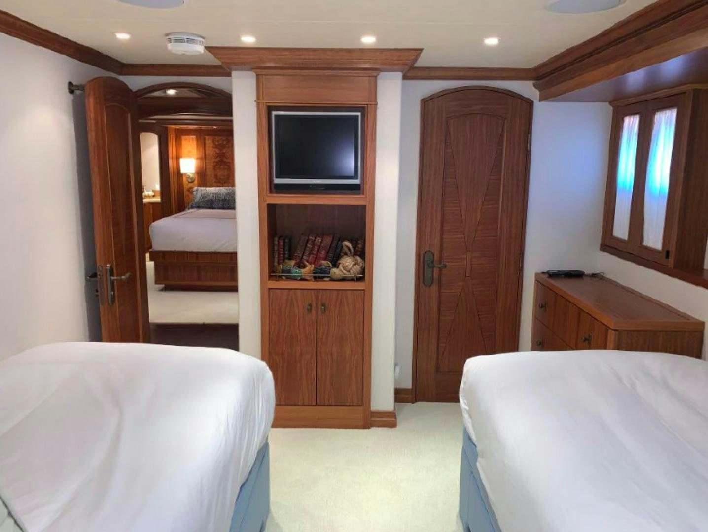 a bedroom with a tv and a closet aboard RAISING DOUGH Yacht for Sale