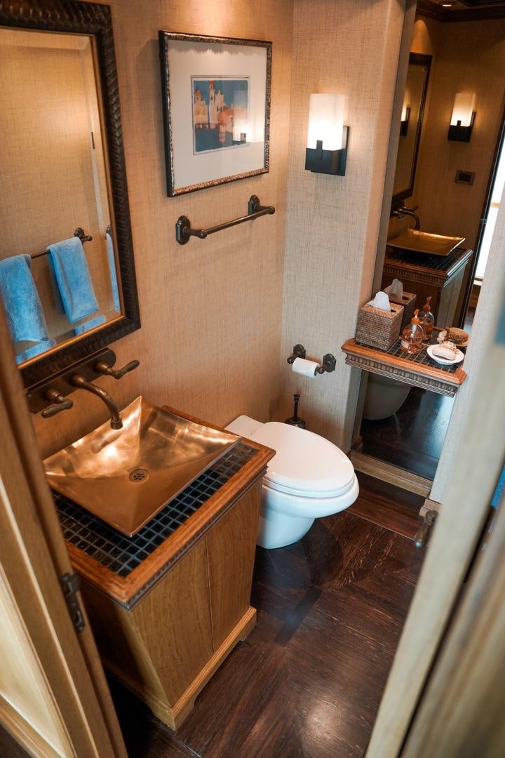 a bathroom with a sink toilet and a mirror aboard RAISING DOUGH Yacht for Sale