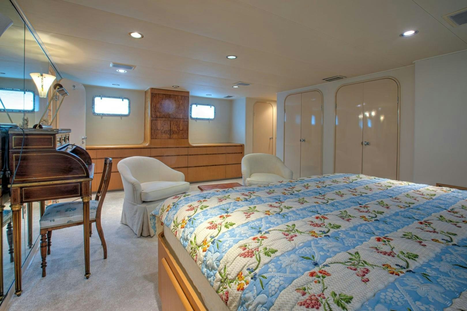 a bedroom with a bed and a chair aboard ZANTINO III Yacht for Sale