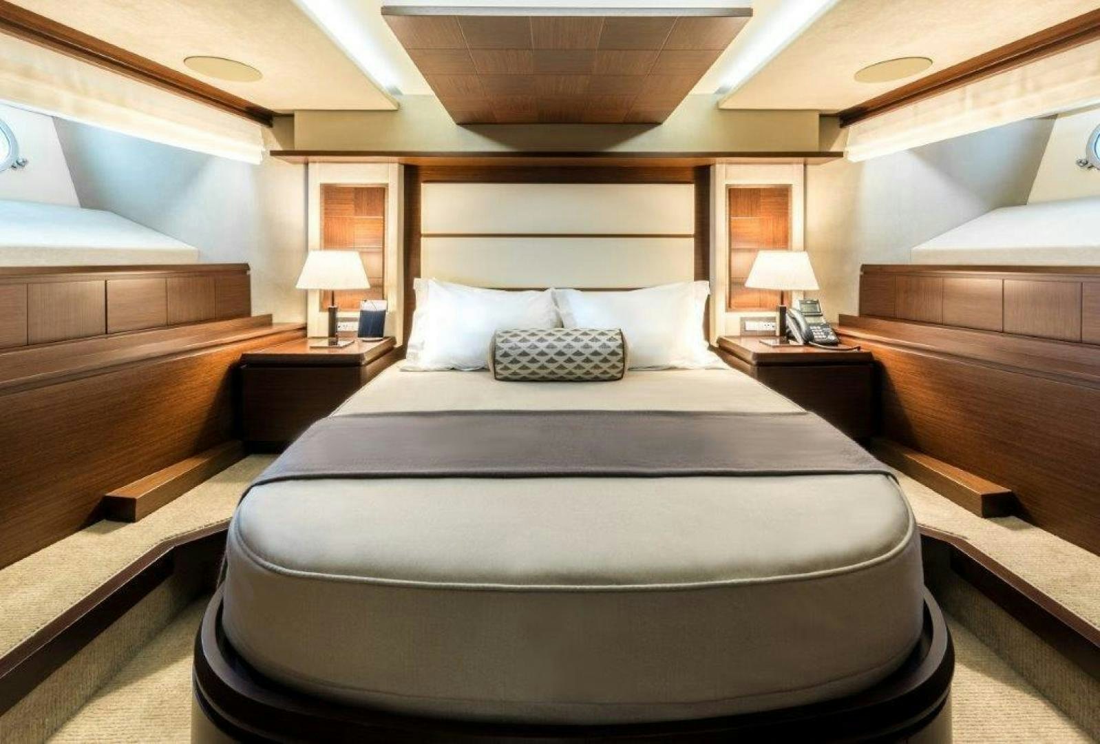a bed with a couple of lamps on either side of it aboard AMANECER Yacht for Sale