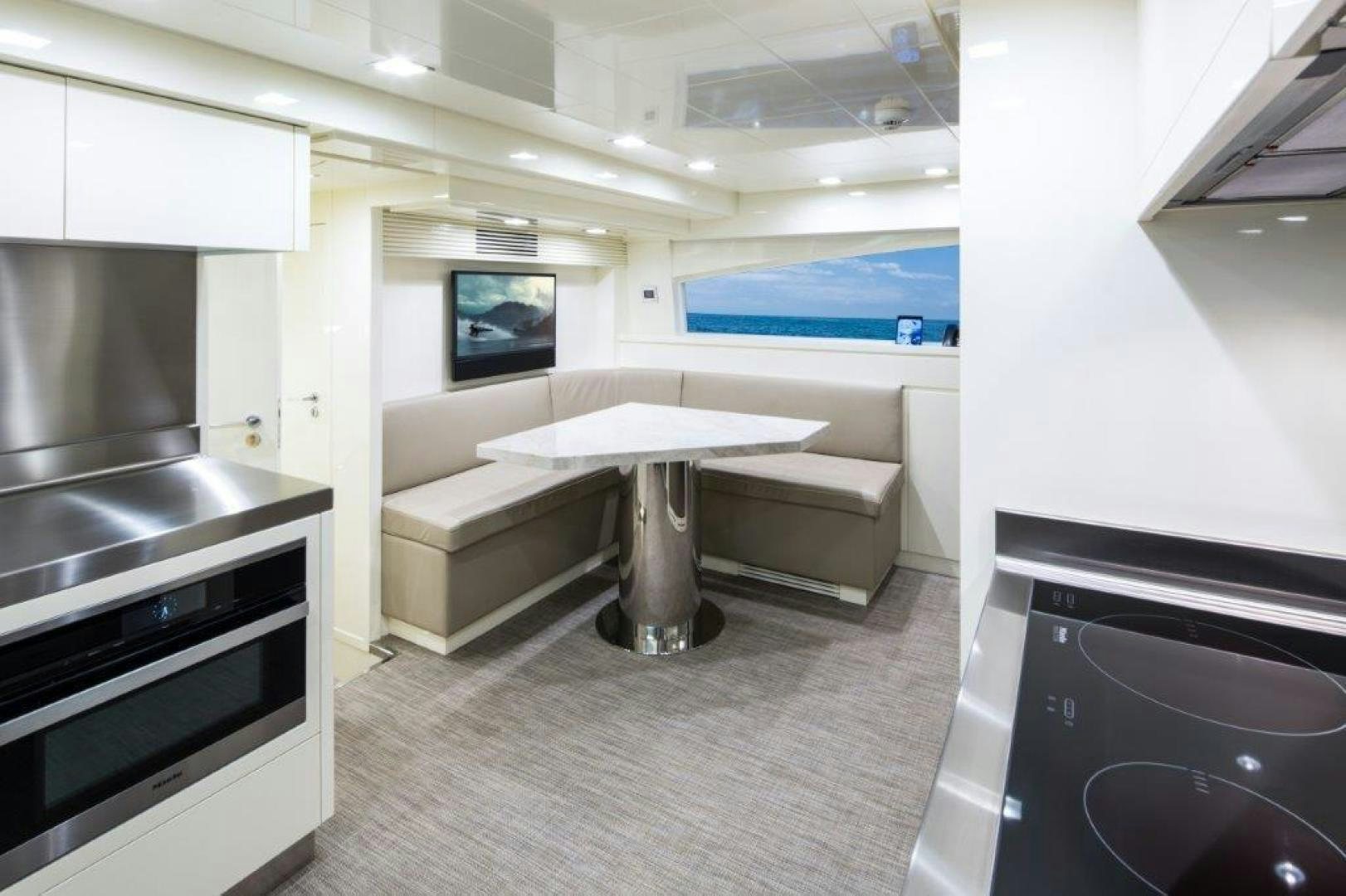 a room with a table and a couch aboard AMANECER Yacht for Sale