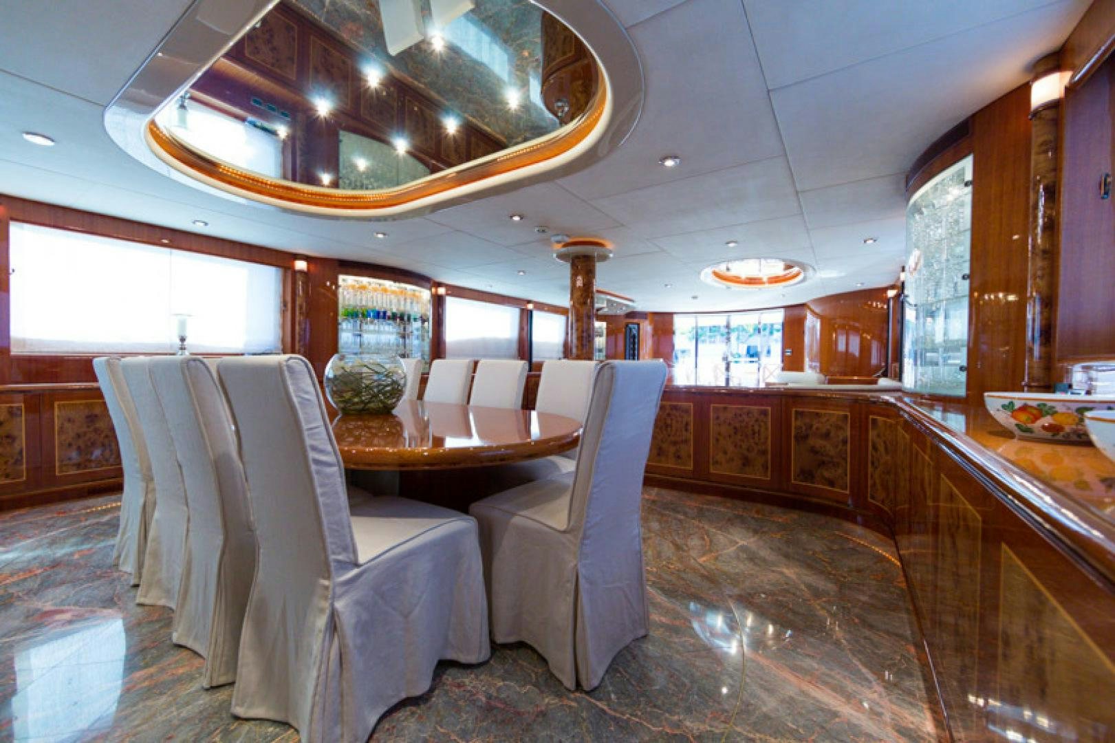 a room with a table chairs and a chandelier aboard MR. CAT Yacht for Sale