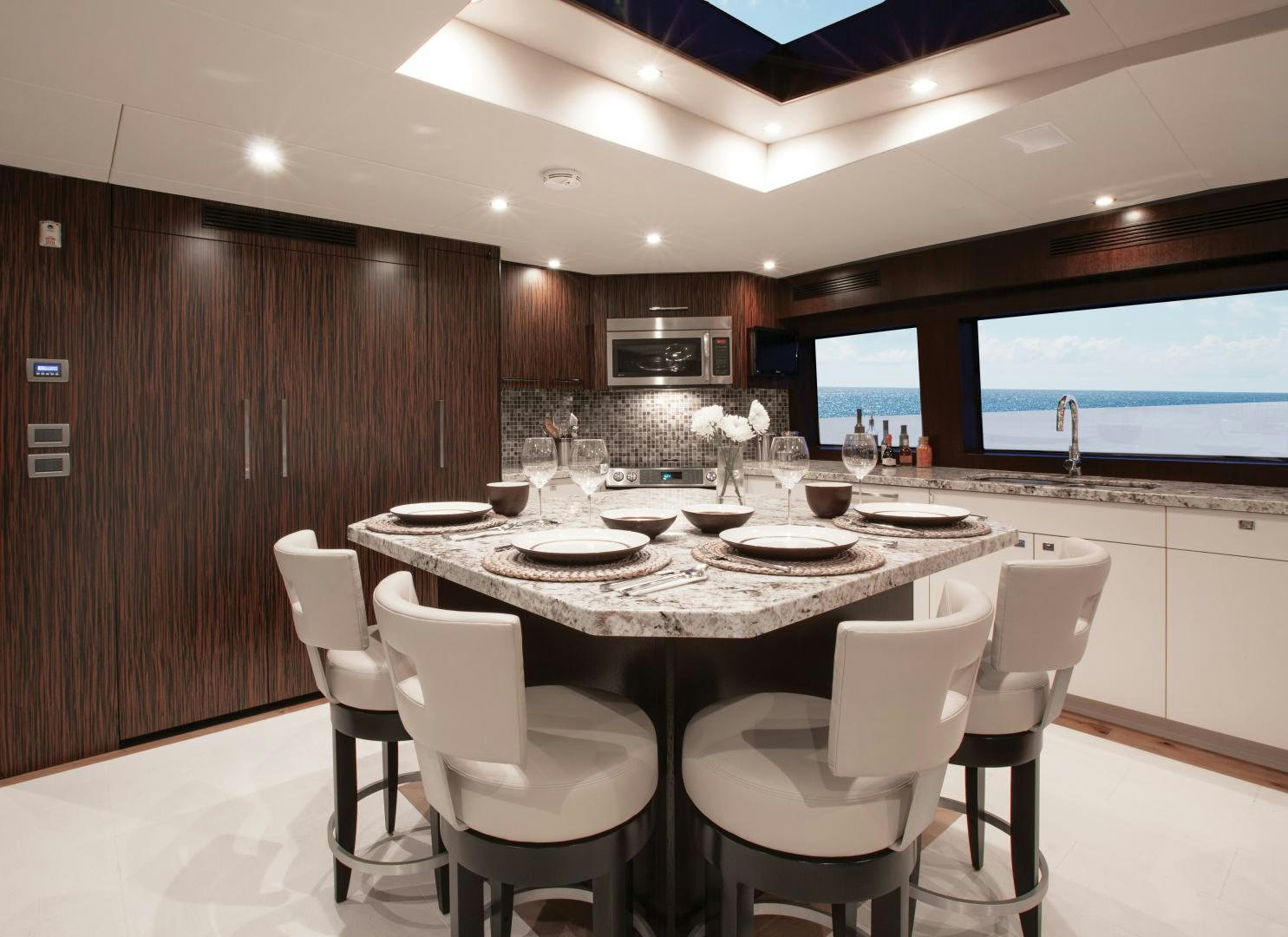 a kitchen with a table and chairs aboard 2021 HATTERAS 105RPH Yacht for Sale